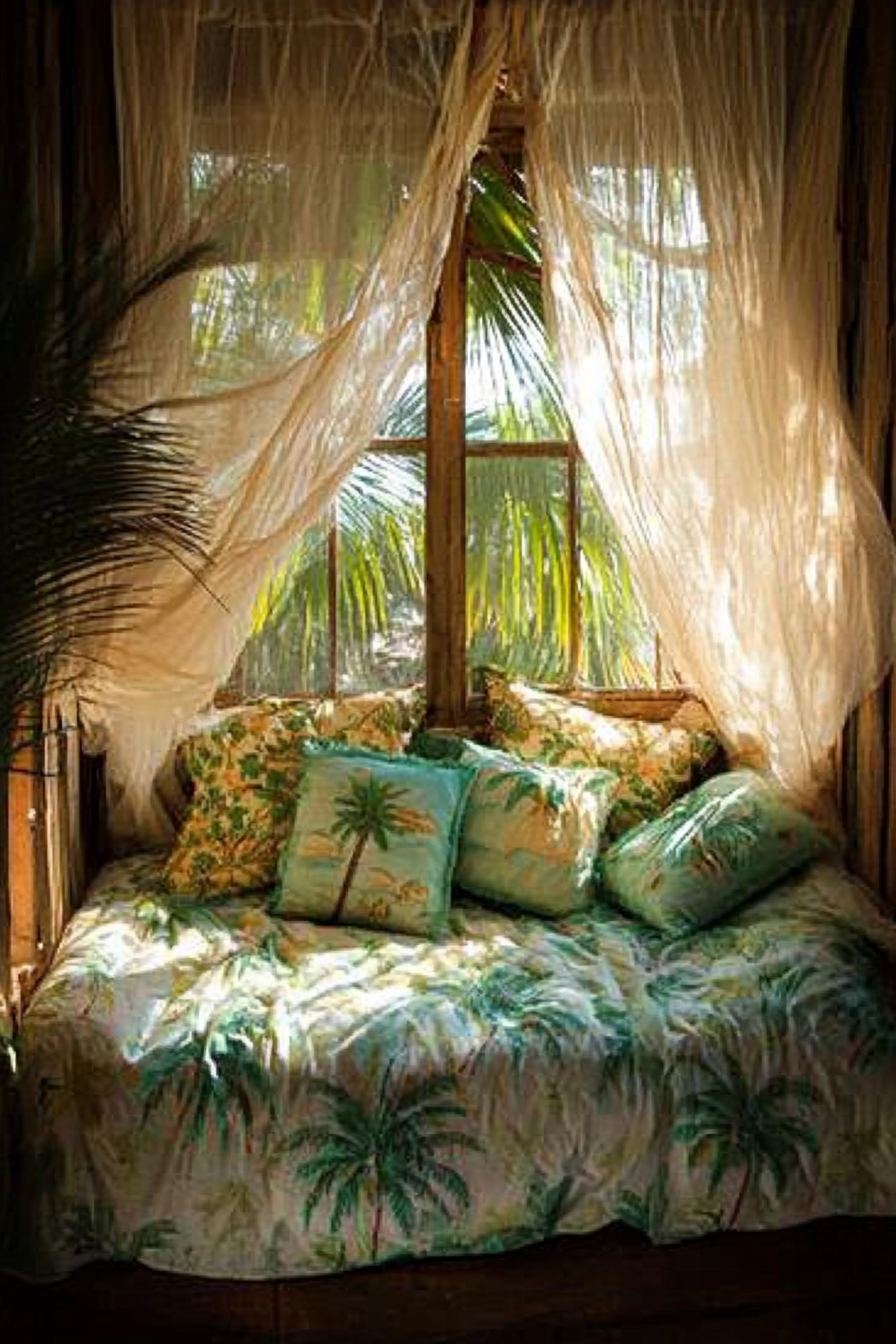 Sleeping nook. Mosquito net drapes and palm tree quilt.